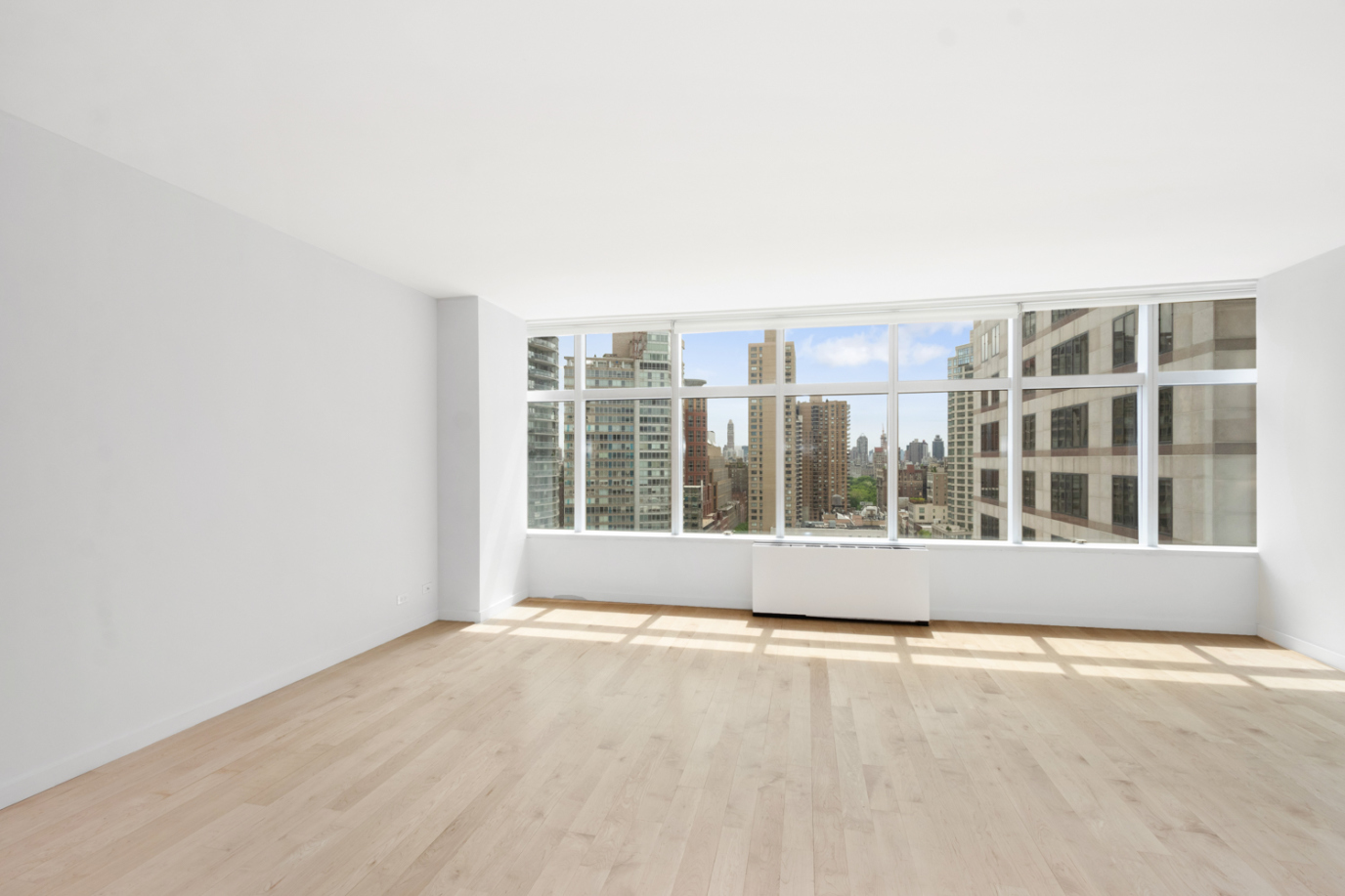 160 West 66th Street, Unit 20F Manhattan, NY 10023 - Photo 3 of 7 an empty room with wooden floor and windows