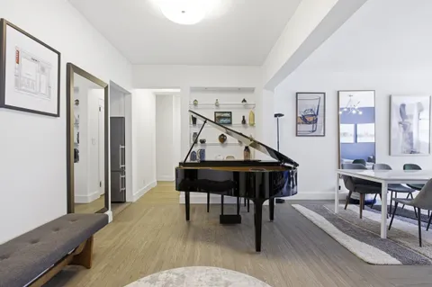 a living room with furniture a piano and a wooden floor