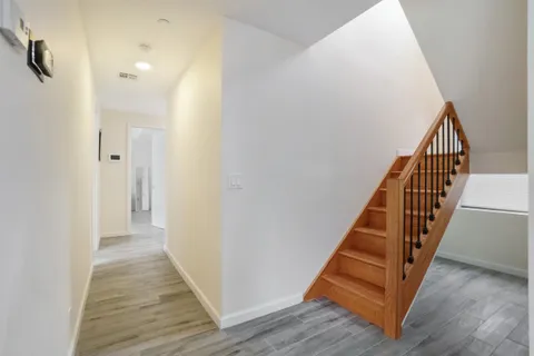 a view of a hallway with wooden floor and staircase