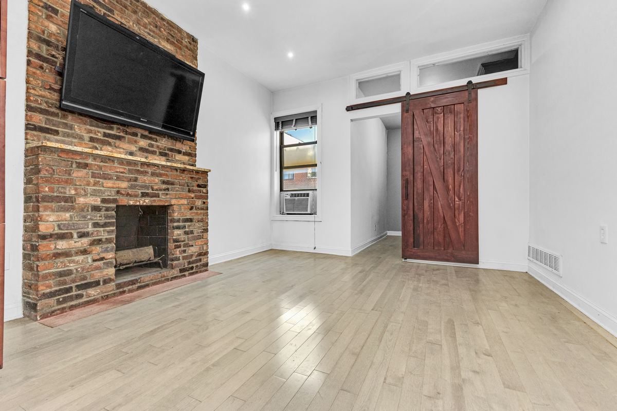 521 Dean Street, Unit 4L Brooklyn, NY 11217 - Photo 8 of 17 a view of empty room with wooden floor and fireplace