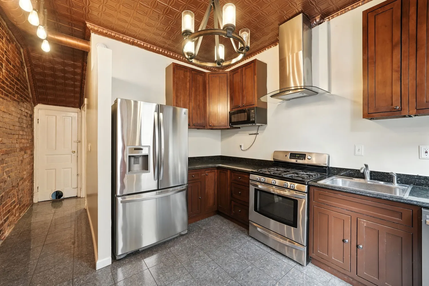 a kitchen with stainless steel appliances granite countertop a stove a refrigerator and a sink with granite countertops