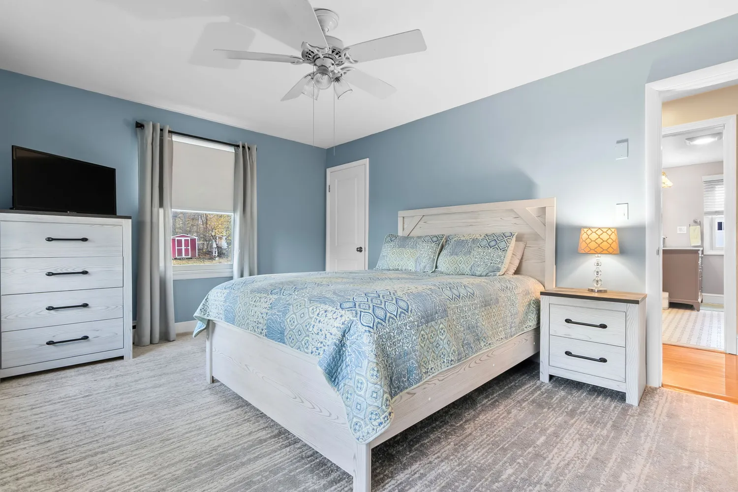 a spacious bedroom with a bed and a flat screen tv