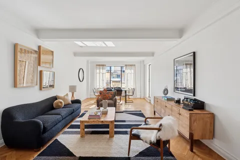 a living room with furniture wooden floor and a window