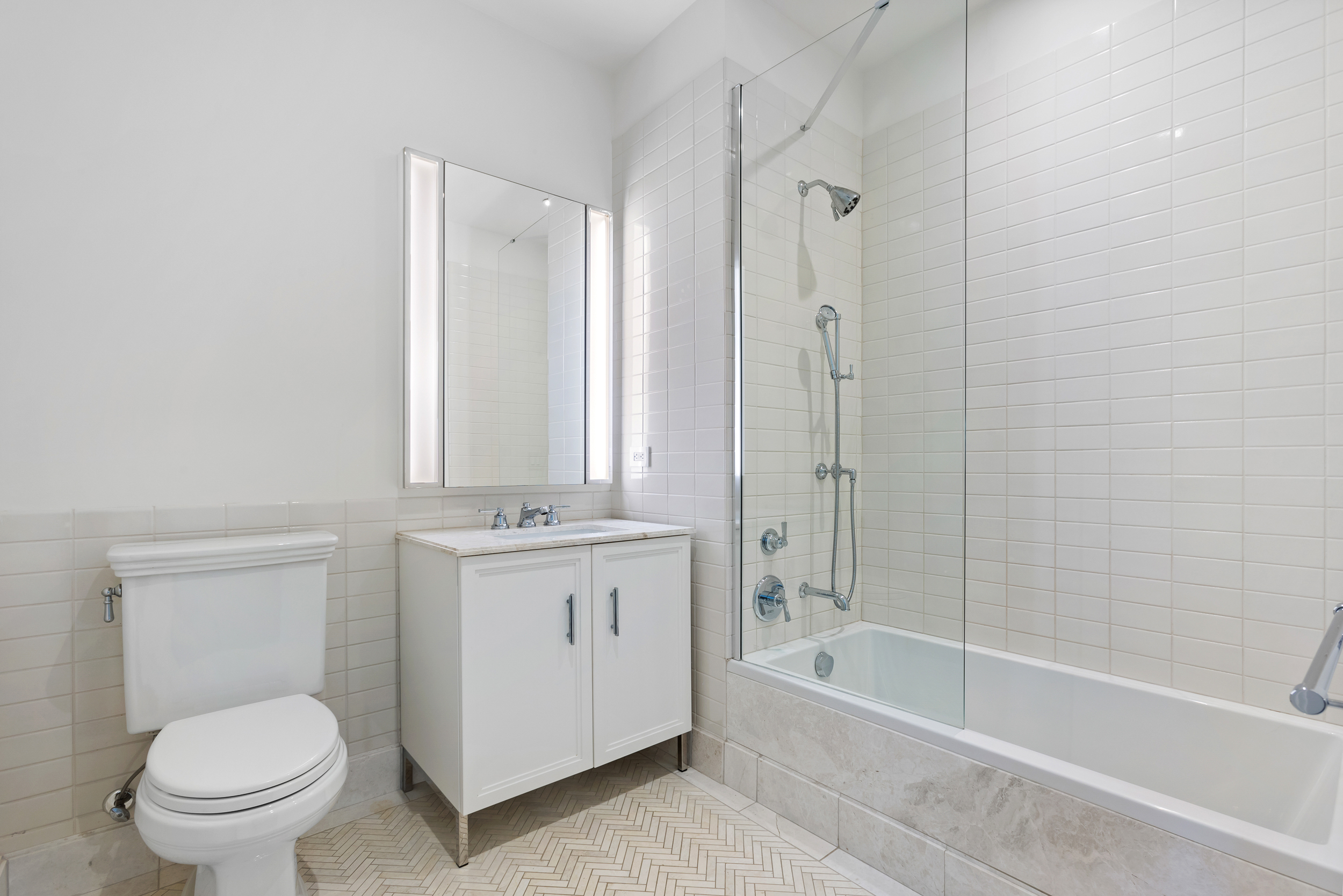 100 Barclay Street, Unit 17A Manhattan, NY 10007 - Photo 10 of 24 a bathroom with a granite countertop toilet a sink and bathtub