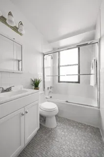 a bathroom with a double vanity sink toilet and a mirror
