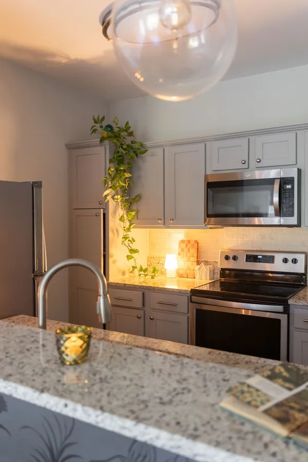 a kitchen with stainless steel appliances granite countertop a stove a sink and a microwave