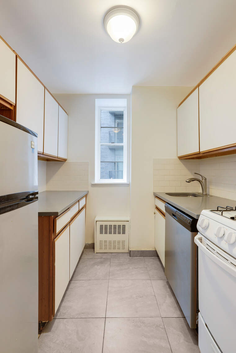 310 East 23rd Street, Unit 5A Manhattan, NY 10010 - Photo 7 of 14 a kitchen with granite countertop a sink and a stove top oven