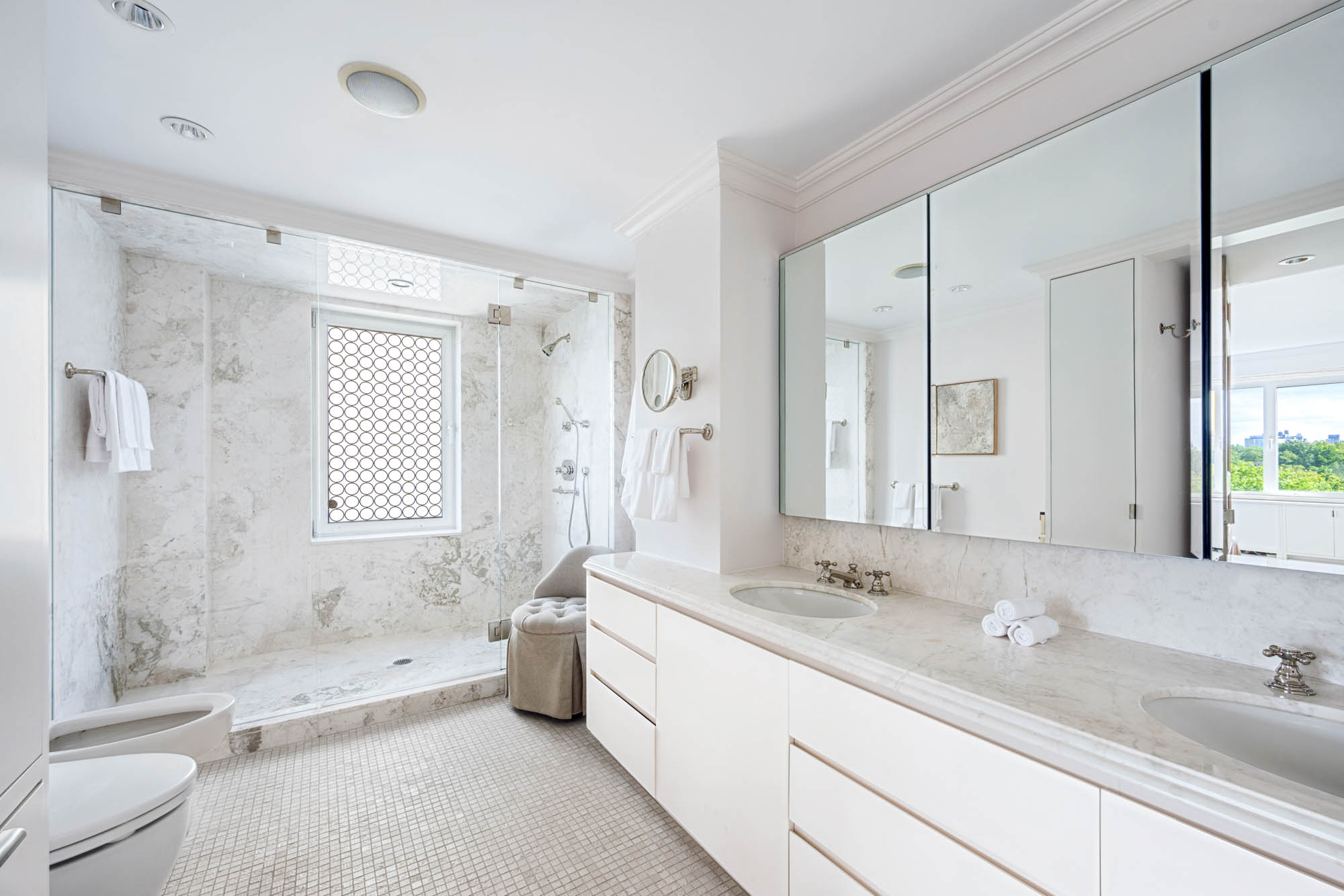 936 5th Avenue, Unit 10AB Manhattan, NY 10021 - Photo 16 of 37 a spacious bathroom with a double vanity sink toilet mirror and bathtub