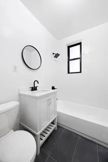 a bathroom with a toilet a sink and mirror