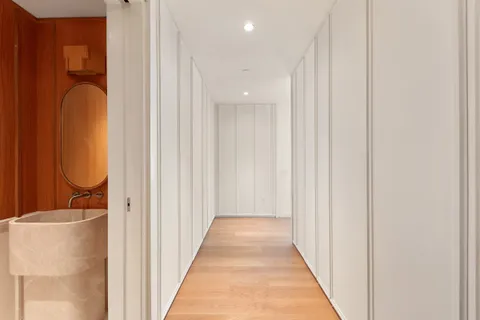 a view of a hallway with wooden floor and glass door