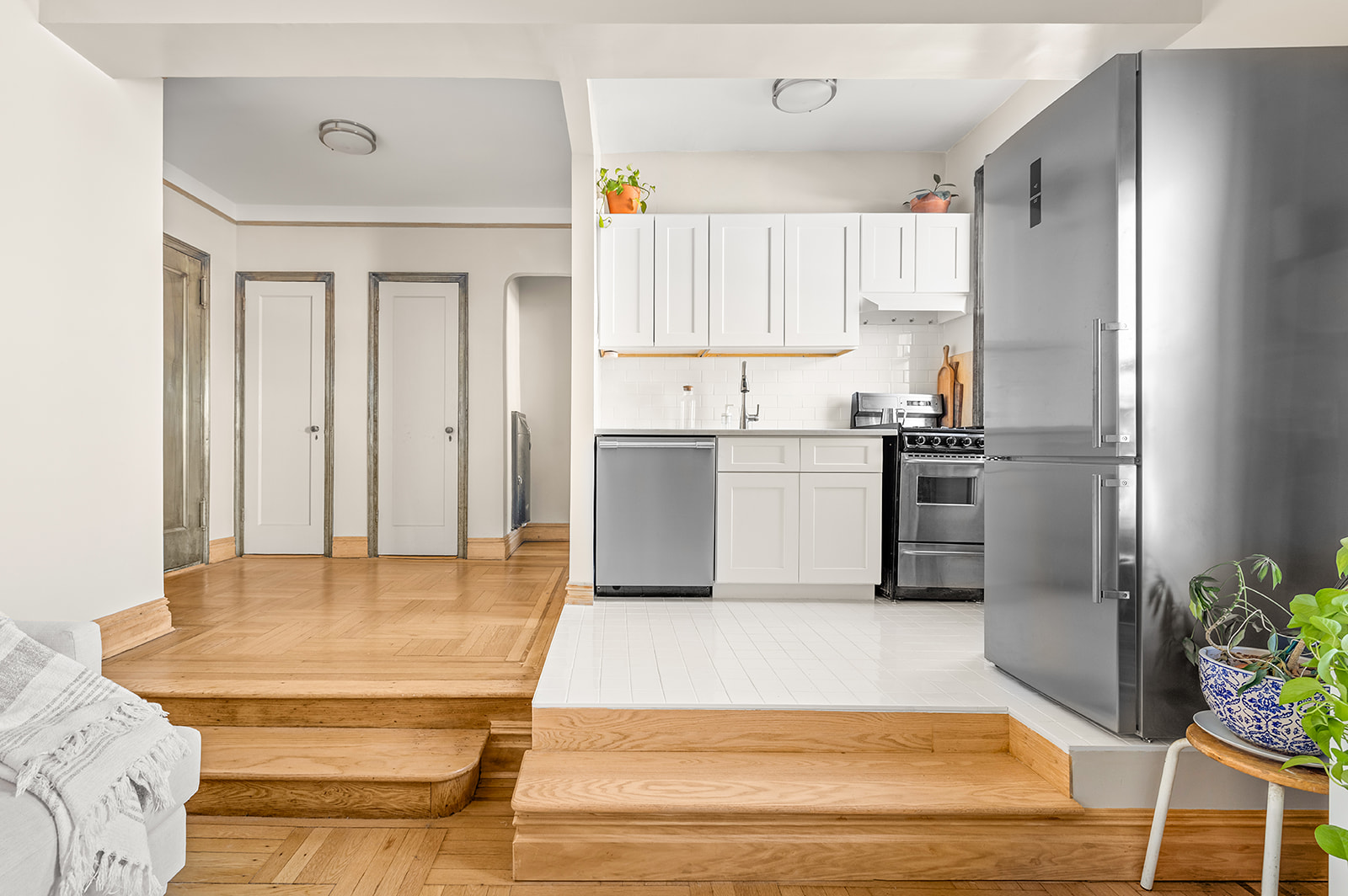 55 Eastern Parkway, Unit 6F Brooklyn, NY 11238 - Photo 2 of 10 a kitchen with stainless steel appliances kitchen island granite countertop a refrigerator a stove and white cabinets with wooden floor
