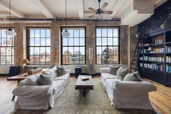 a living room with furniture floor to ceiling window and a flat screen tv