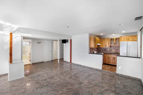 a view of a kitchen with refrigerator and white cabinets