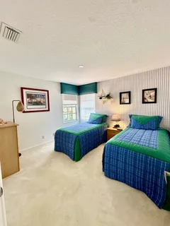 a bedroom with two beds and a dresser