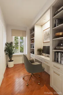 a view of a workspace with furniture and a window