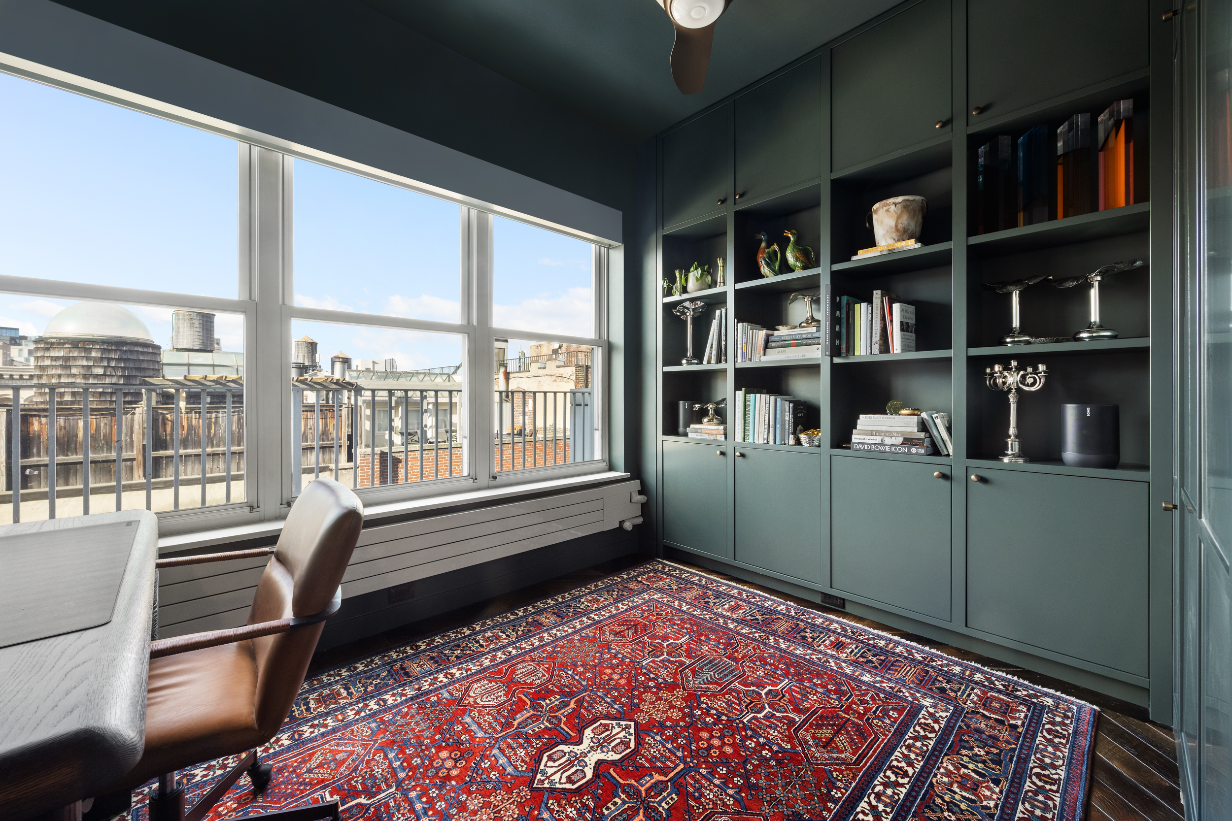 109 Greene Street, Unit PH6A Manhattan, NY 10012 - Photo 12 of 26 a room with bookshelf and a large window