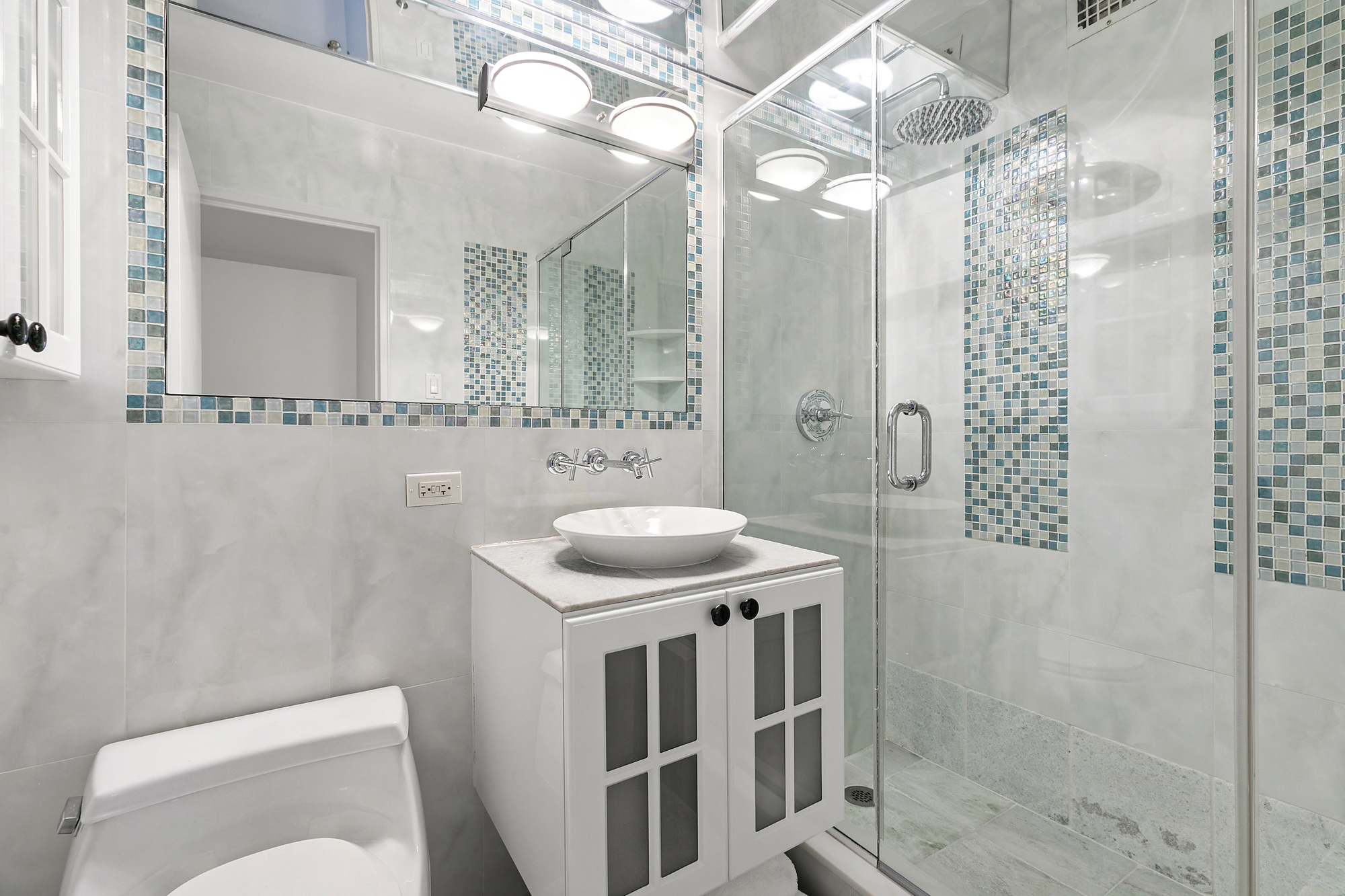 1199 Park Avenue, Unit 10K Manhattan, NY 10128 - Photo 9 of 12 a bathroom with a sink a toilet a mirror and shower