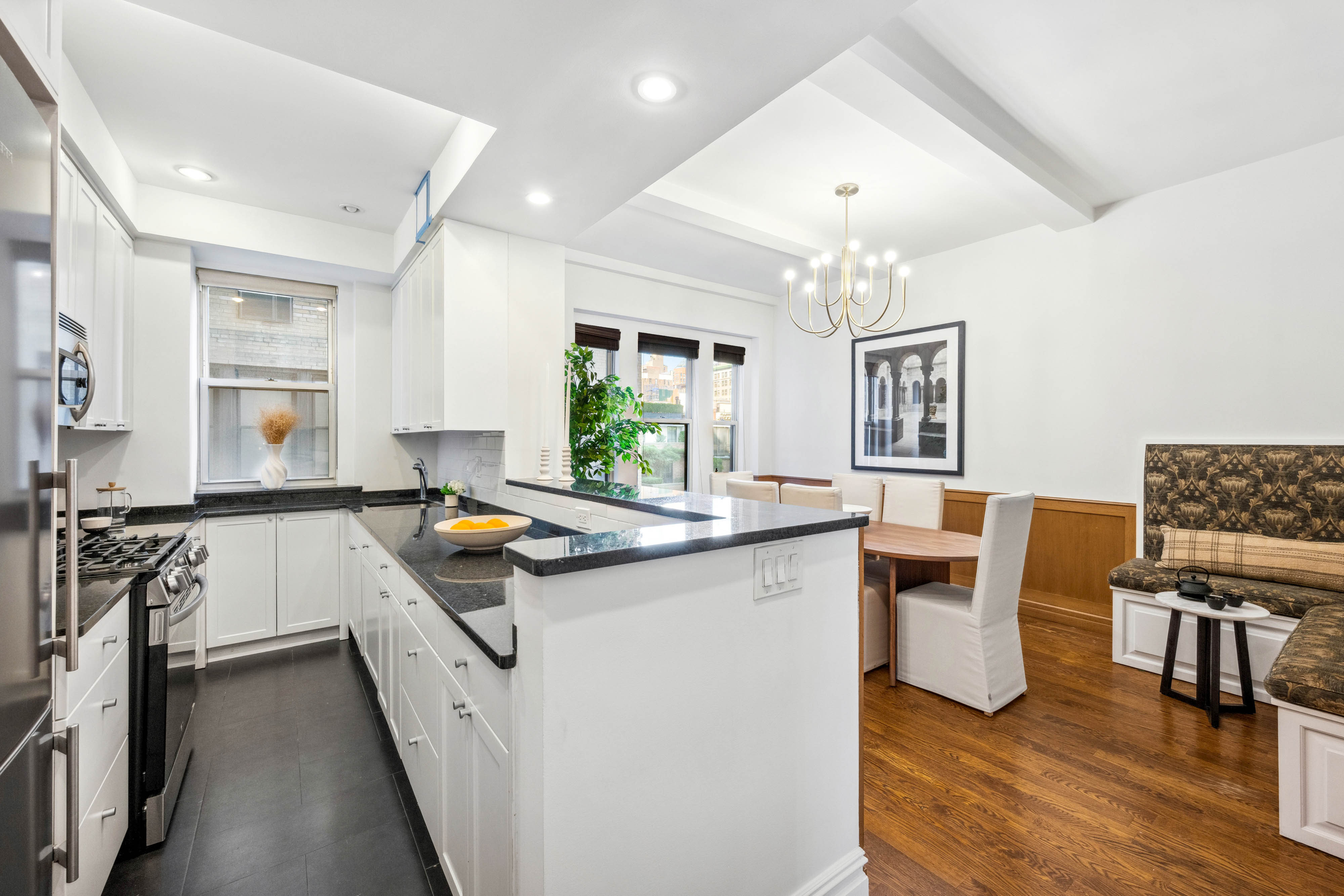 25 5th Avenue, Unit 6C Manhattan, NY 10003 - Photo 5 of 16 a kitchen with granite countertop a stove top oven sink and cabinets