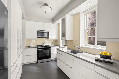 a kitchen with a sink a stove and cabinets