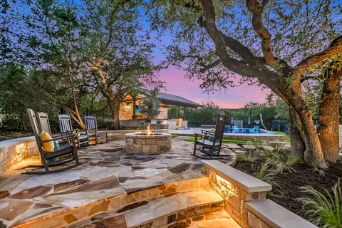 a backyard of a house with plants and large trees