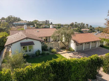 a view of a house with a big yard plants and large trees