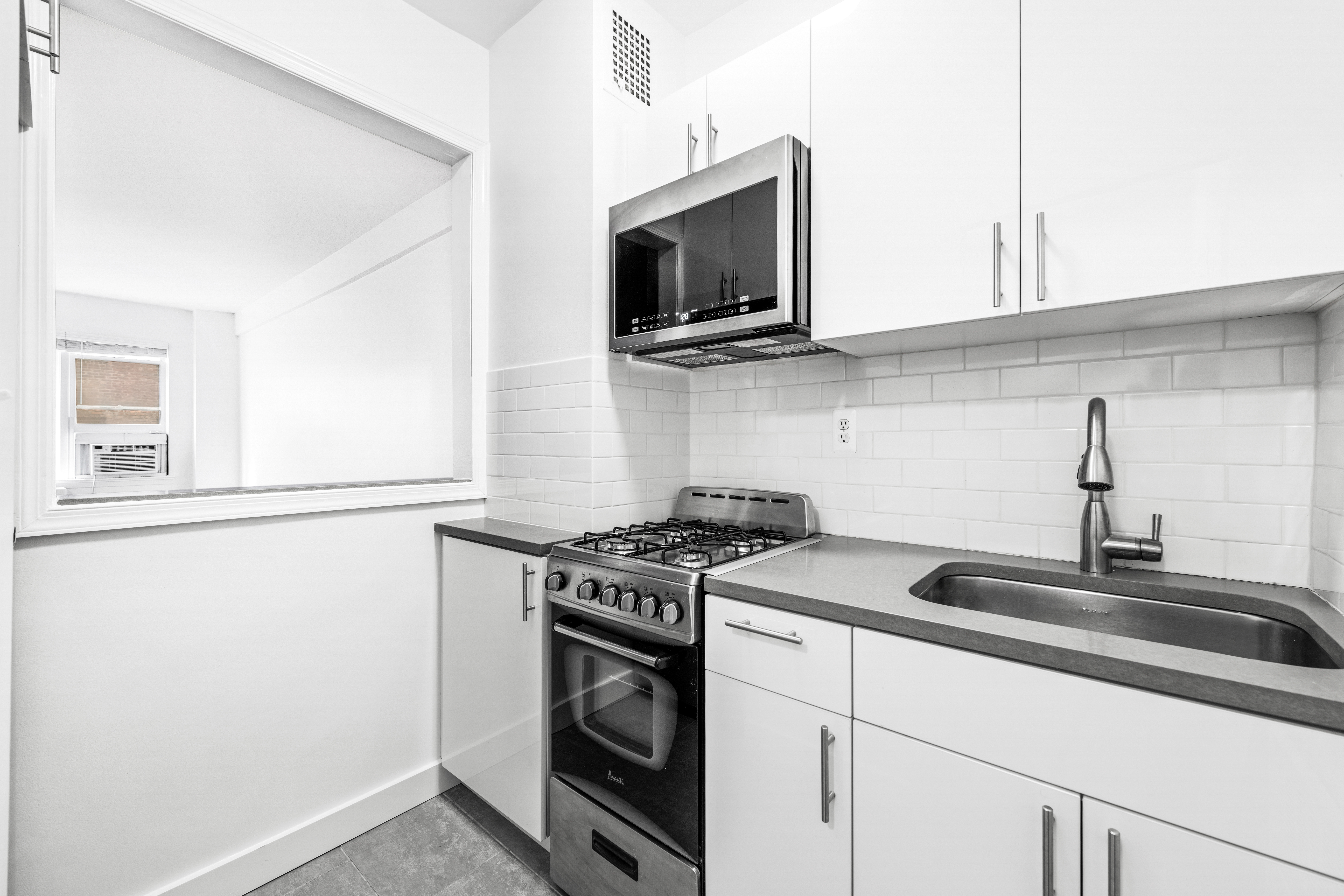 240 East 46th Street, Unit 8H Manhattan, NY 10017 - Photo 4 of 6 a kitchen with stainless steel appliances granite countertop a sink and a stove top oven with granite countertops
