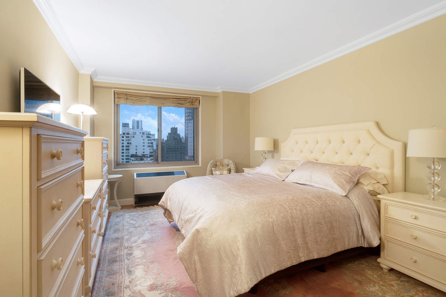 300 East 74th Street, Unit 18E Manhattan, NY 10021 - Photo 6 of 10 a bedroom with a large bed and a window