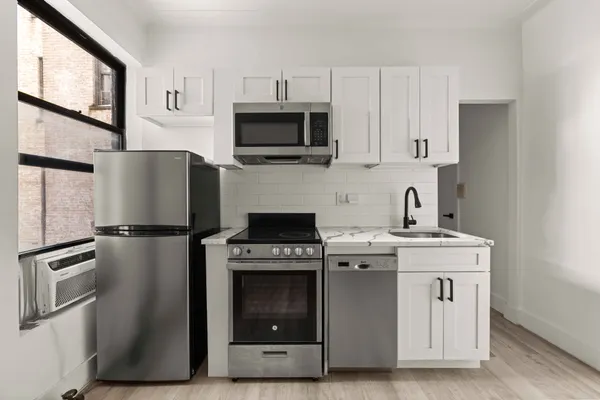 a kitchen with stainless steel appliances granite countertop a stove a refrigerator and a microwave