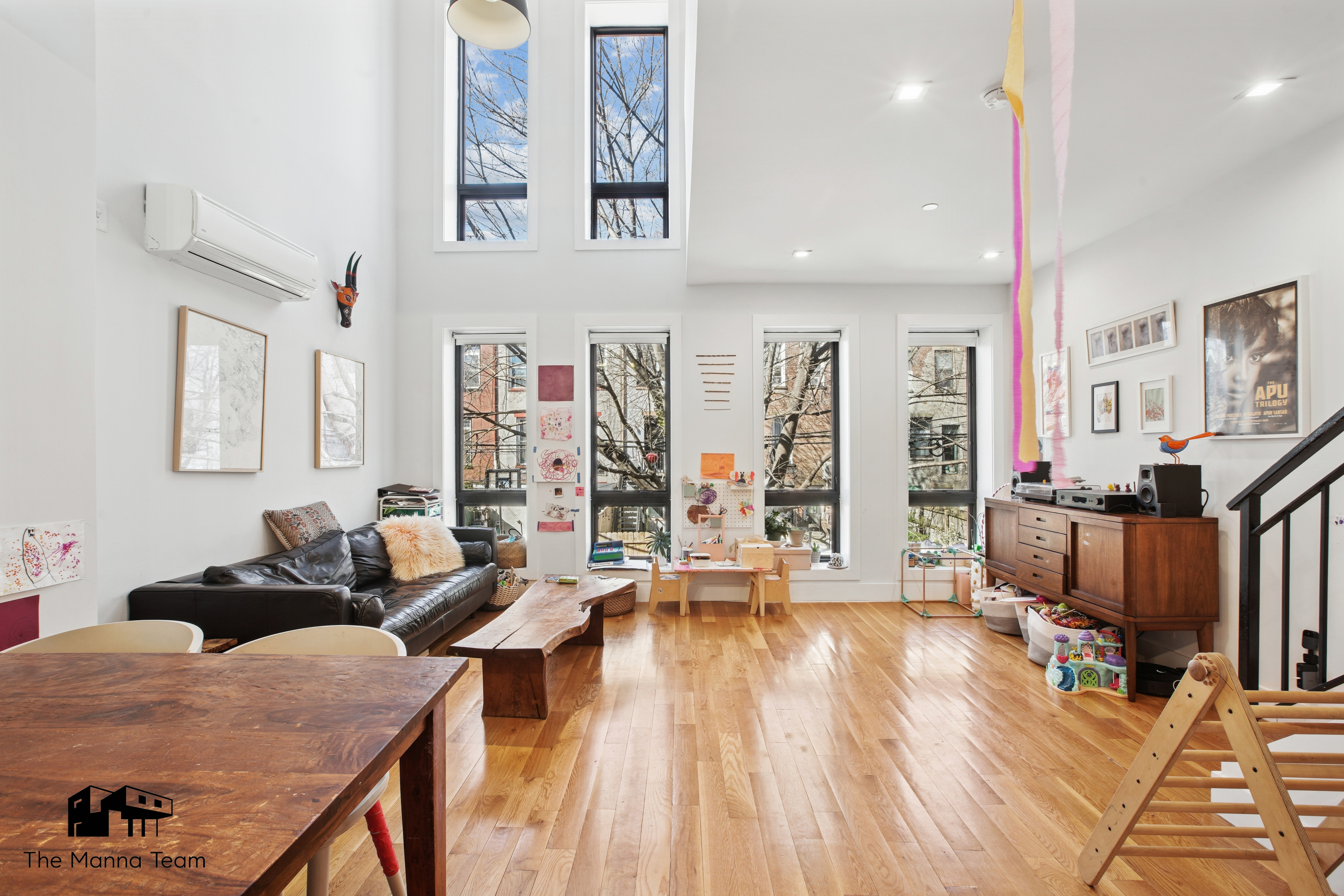 a living room with furniture a wooden floor and next to a window