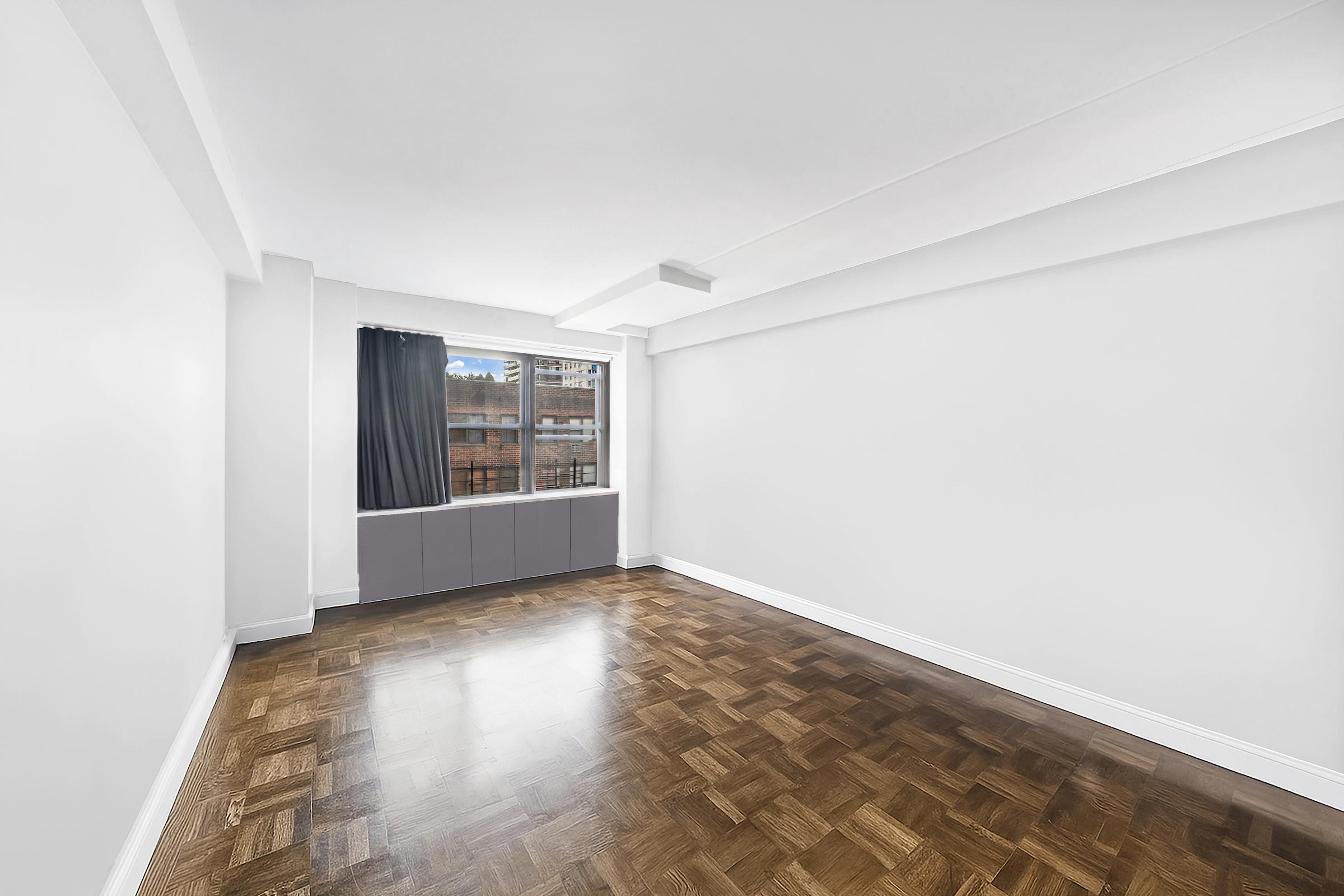 2 Tudor City Place, Unit 11KN Manhattan, NY 10017 - Photo 10 of 14 a view of an empty room with wooden floor and a window