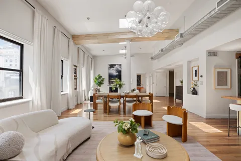 a living room with furniture dining table and a chandelier