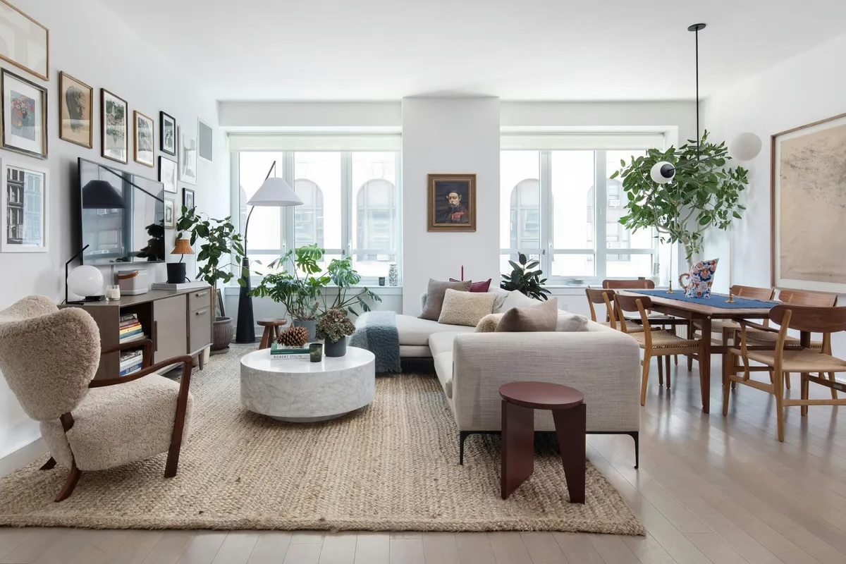 a living room with furniture potted plant and a large window