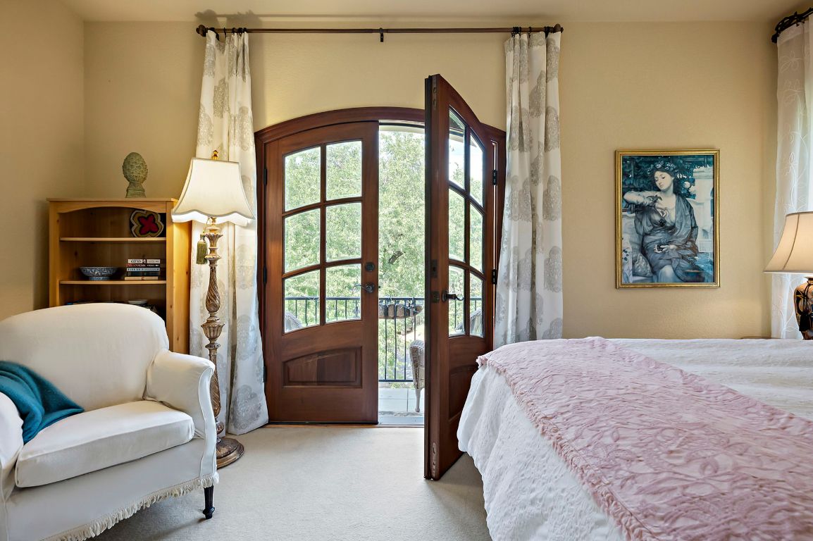1607 The High Road Austin, TX 78746 - Photo 20 of 28 a bedroom with a balcony a bed and a couch