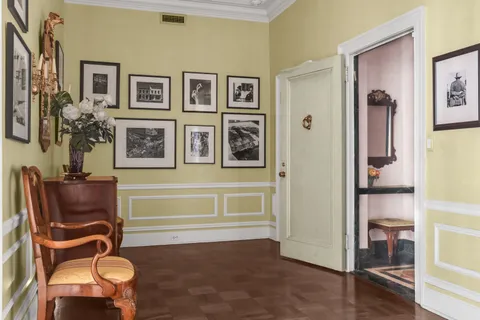 a room that has painting on the wall and a potted plant