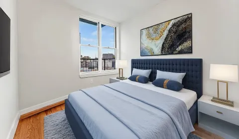 a bedroom with a bed and a painting on the wall