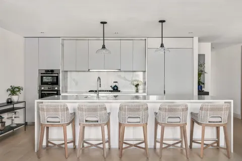 a kitchen with granite countertop cabinets and chairs