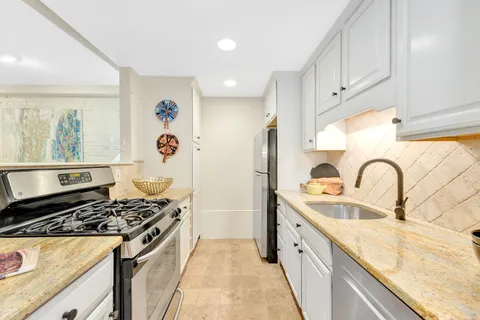 a kitchen with stainless steel appliances granite countertop a sink stove and refrigerator