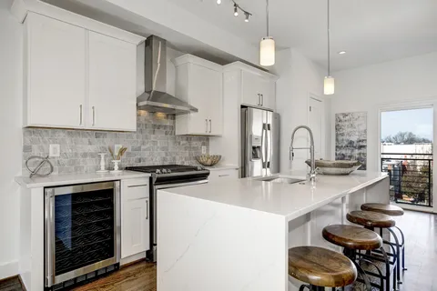 a kitchen with cabinets and chairs