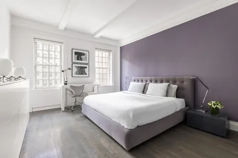 a bedroom with a bed table and a window