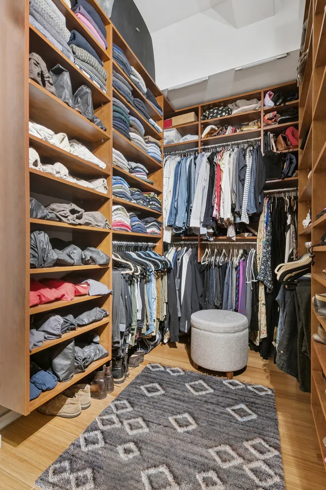 a view of walk in closet with clothes and shoes