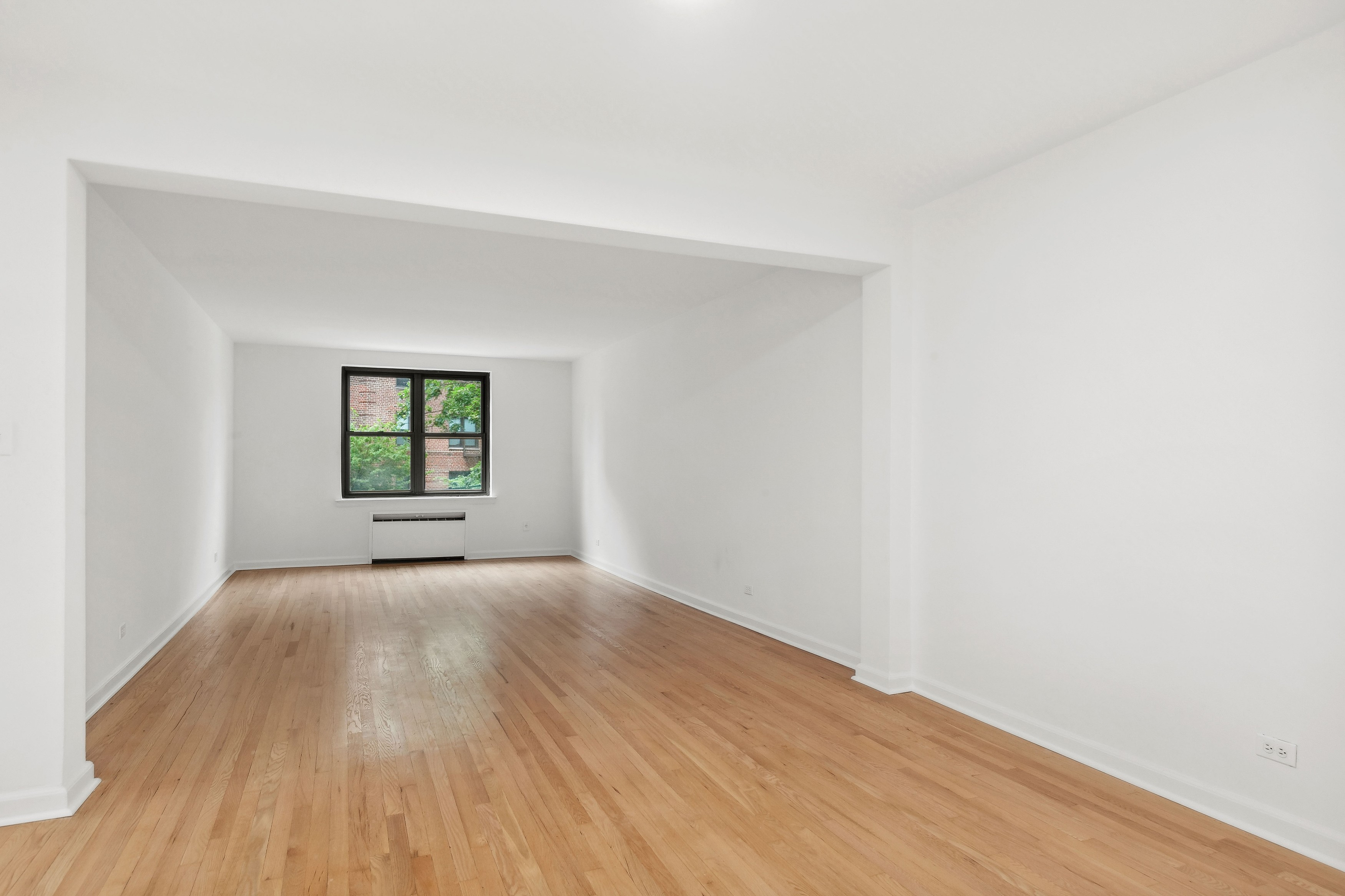445 West 240th Street, Unit 3A Bronx, NY 10463 - Photo 2 of 8 an empty room with wooden floor and windows