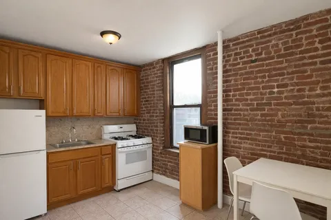 a view of a kitchen with sink and refrigerator