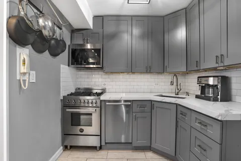 a kitchen with stainless steel appliances granite countertop a sink a stove and cabinets