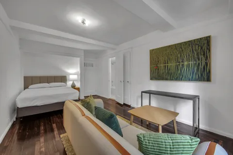 a bedroom with furniture and a wooden floor