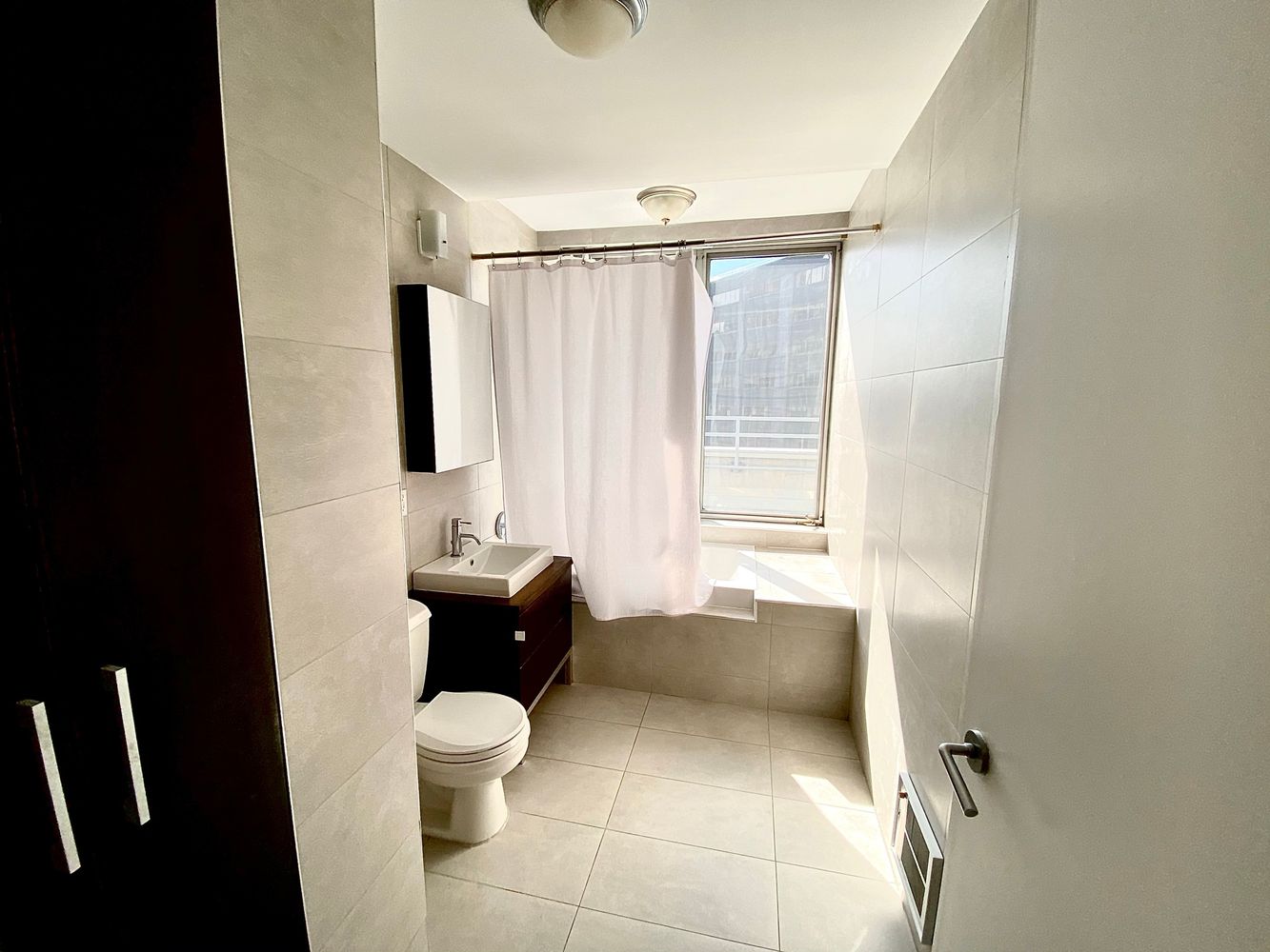 13-11 Jackson Avenue, Unit 9B Queens, NY 11101 - Photo 9 of 11 a bathroom with a toilet sink and a mirror