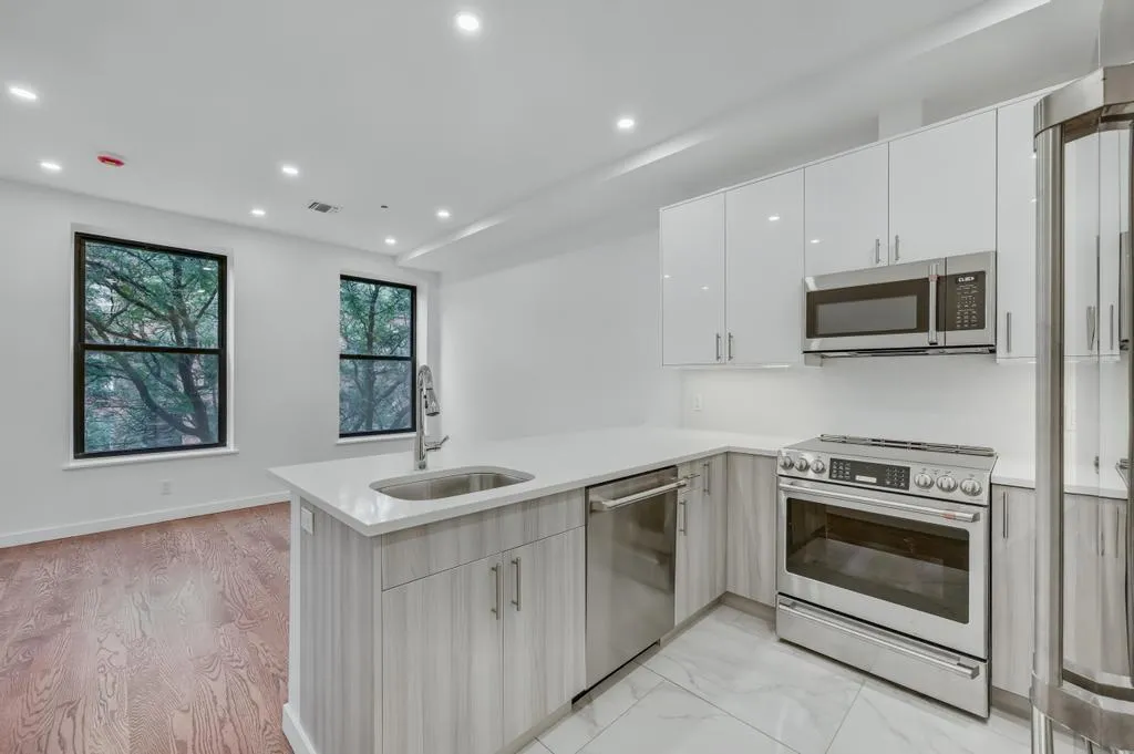 a kitchen that has a sink a stove and microwave