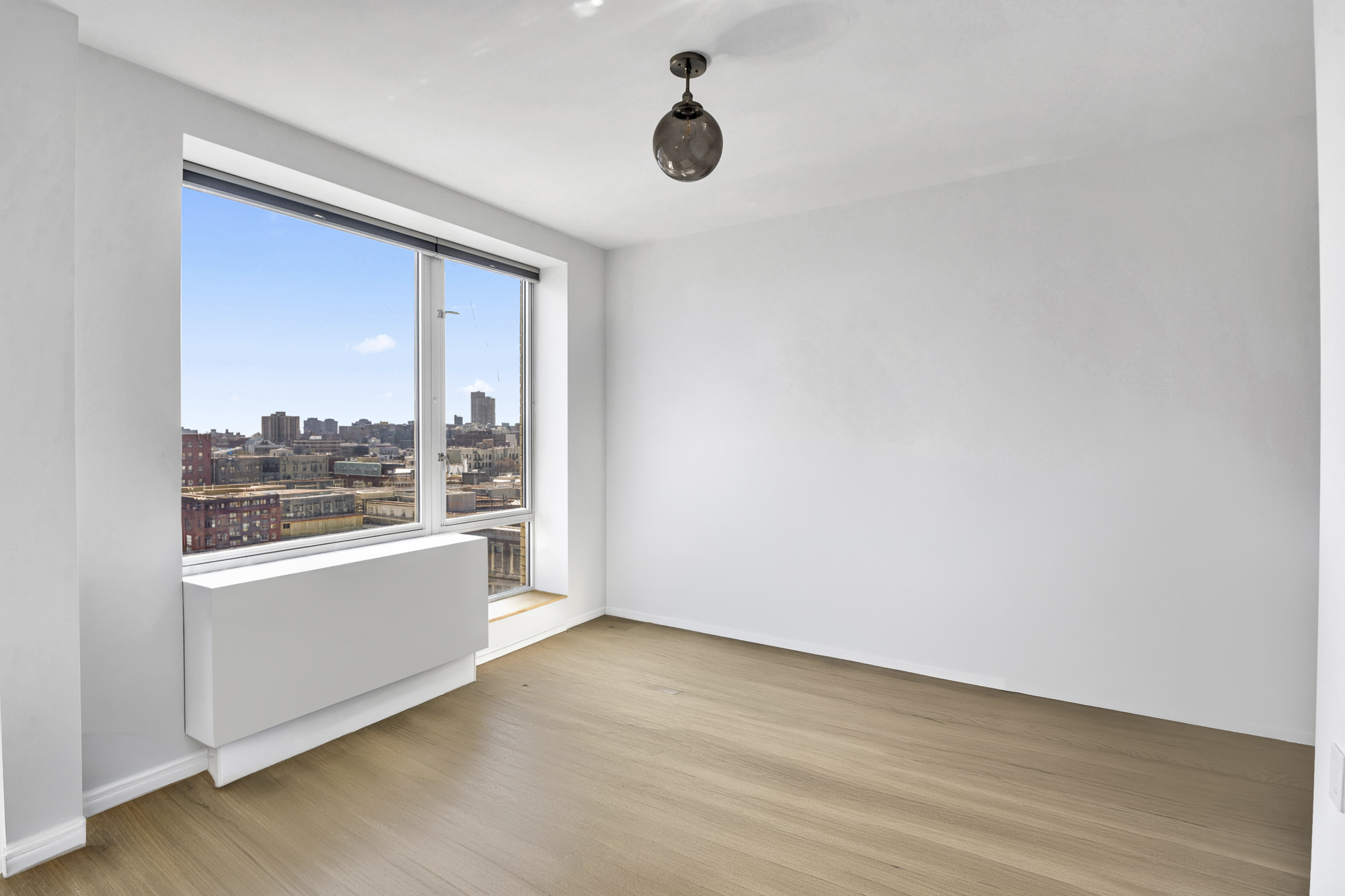 2280 Frederick Douglass Boulevard, Unit 10B Manhattan, NY 10027 - Photo 6 of 15 wooden floor in an empty room with a window
