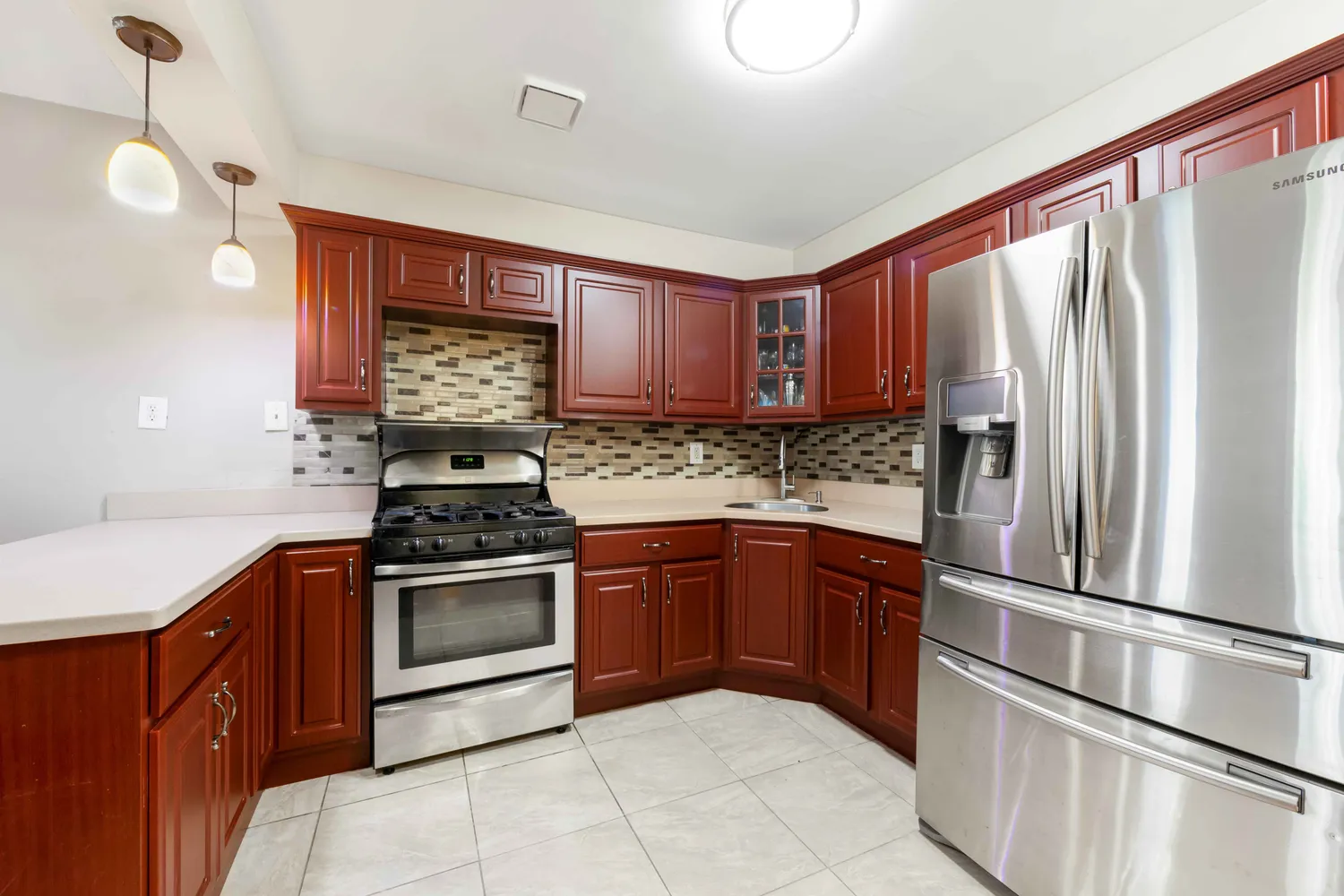a kitchen with stainless steel appliances granite countertop a refrigerator sink and stove