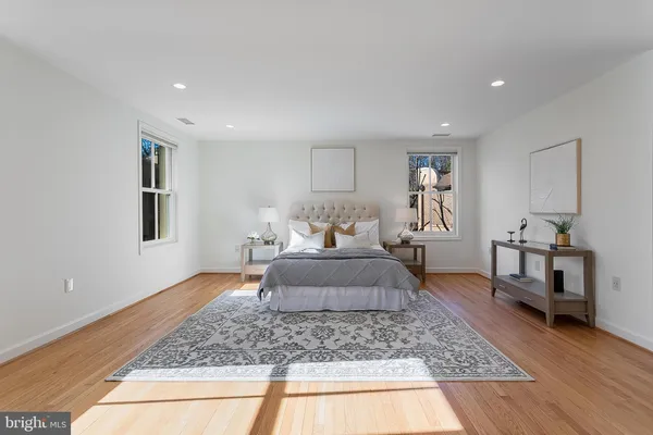 a bedroom with a large bed and wooden floor
