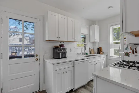 a kitchen with white cabinets and appliances